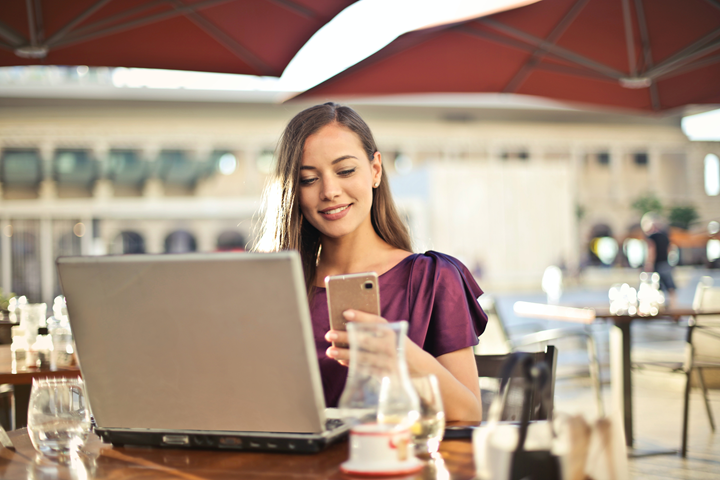 Female looking at phone and laptop