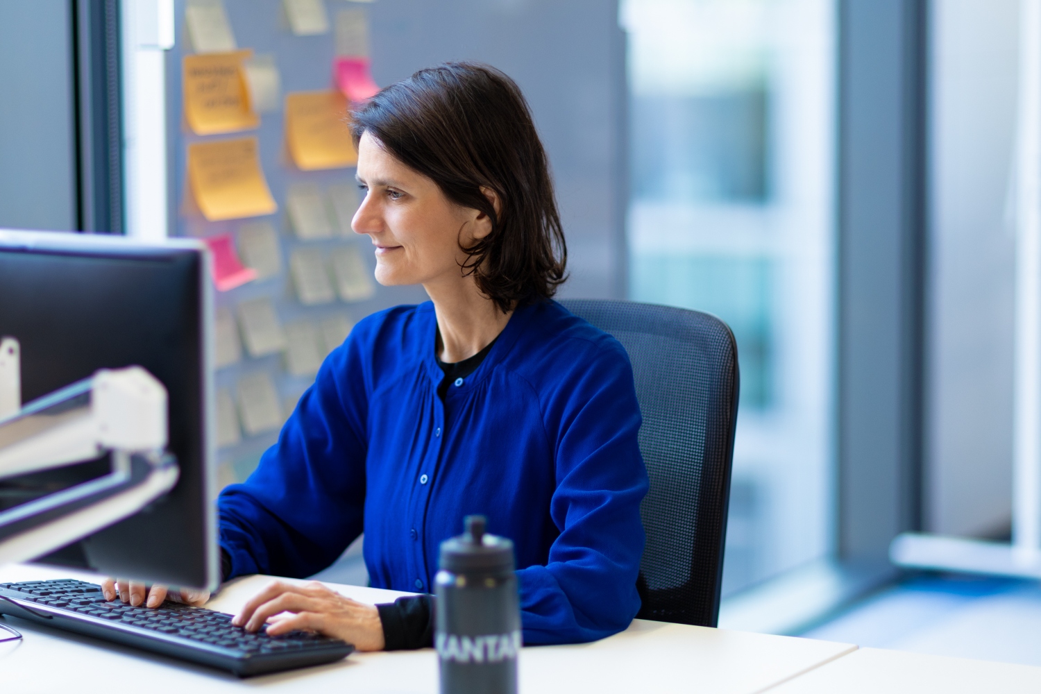 Woman in blue working at her desktop